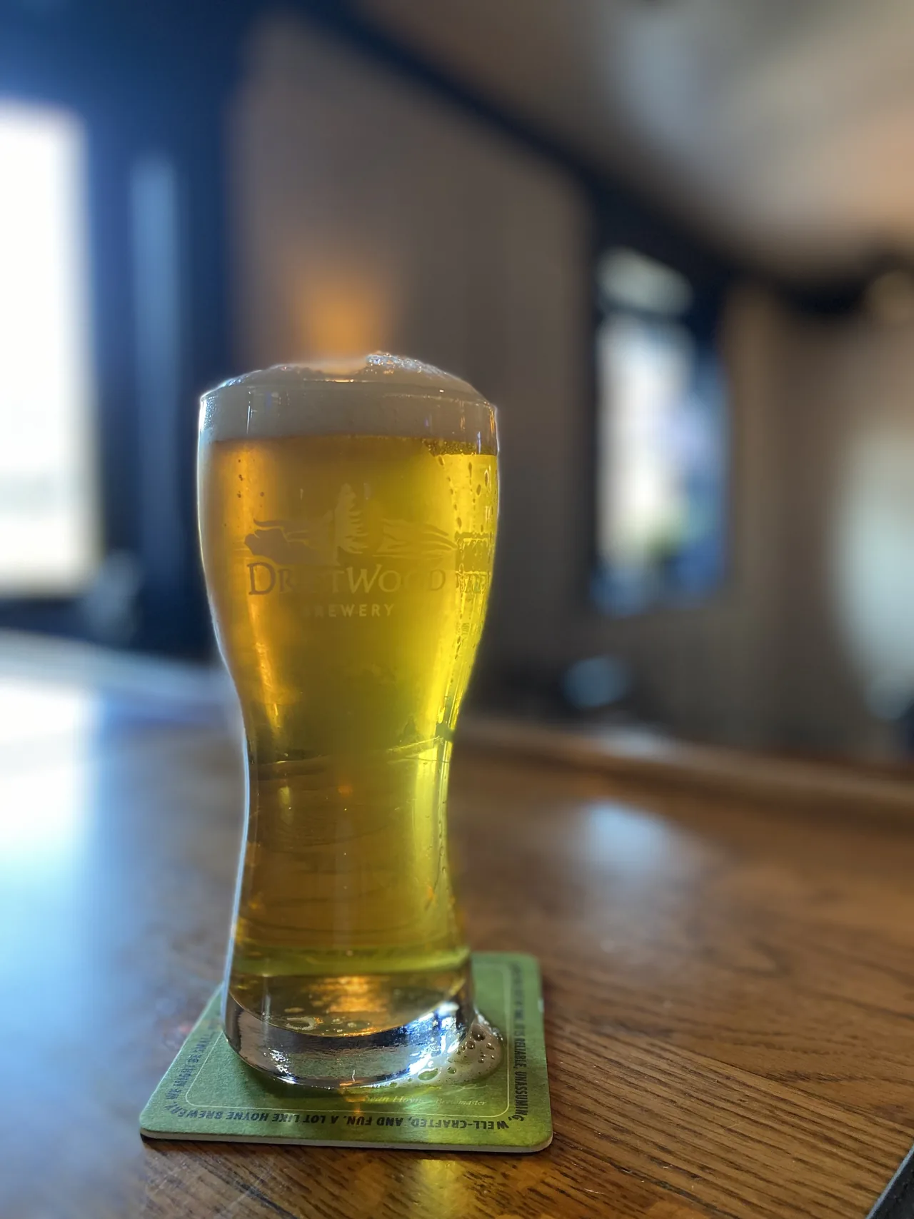 A cold pint of the house lager resting on a coaster