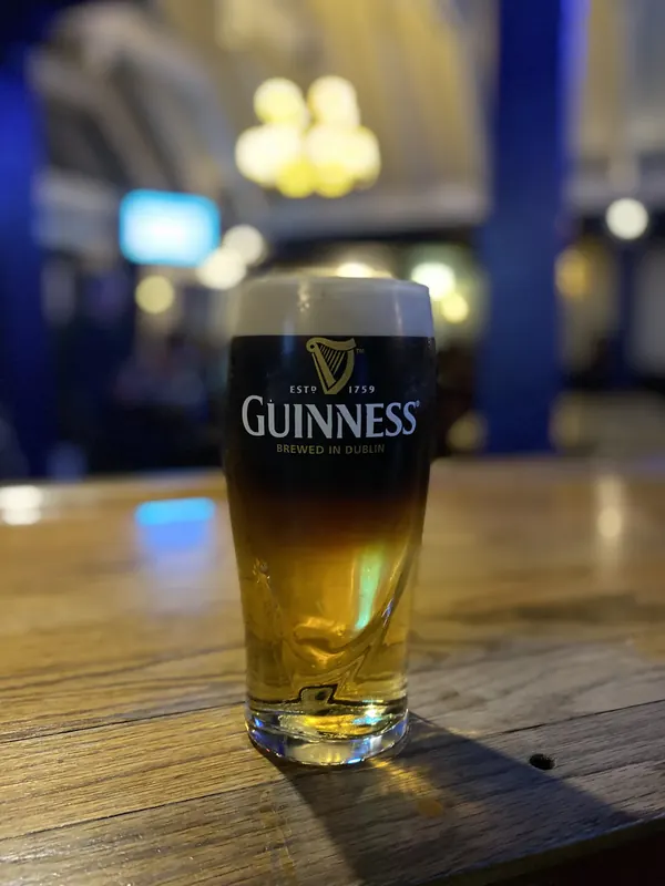 A Guinness and a lager side by side on the bar