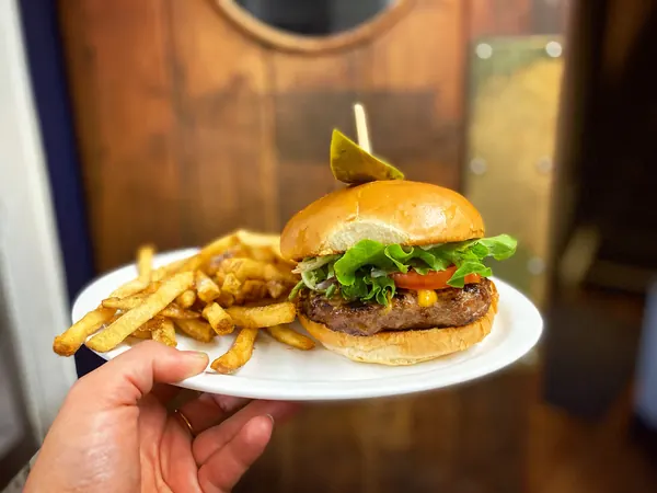 A burger and fries carried to the table