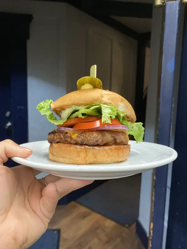 A burger on a white plate, served fresh