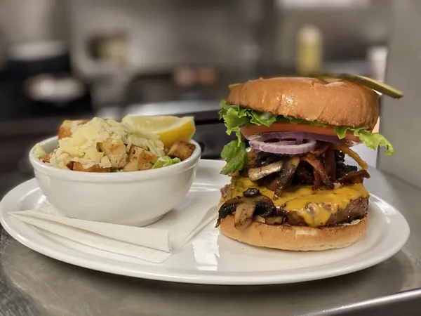 Burger with red onion and a side salad