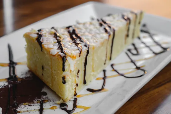 Coconut cream slice dusted with icing sugar