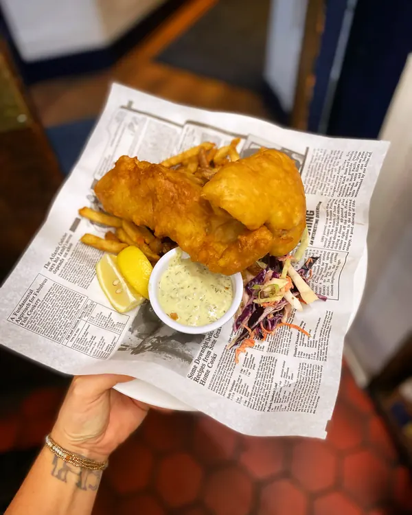Fish and chips served in paper with coleslaw and tartar