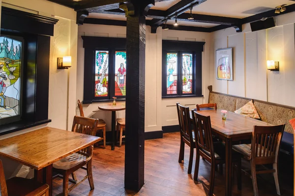 A quiet corner with stained glass windows, wall sconces and a cushioned bench seat