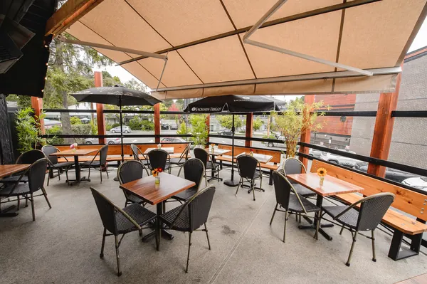 The upstairs deck under its awning, tables set with flowers
