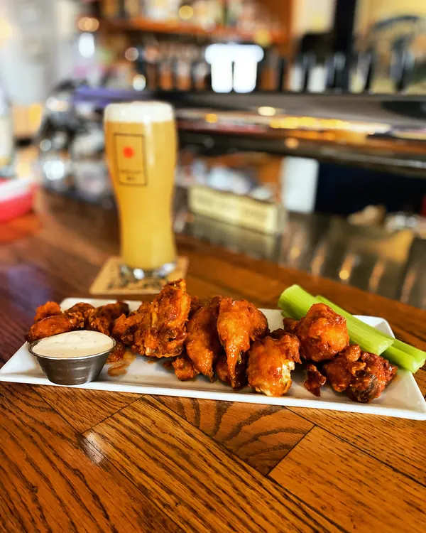 Wings and a tall lager on the bar