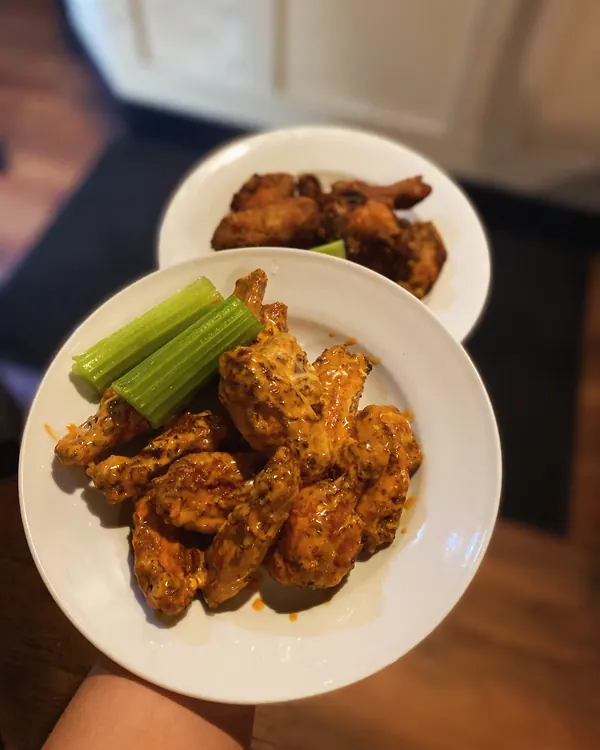 Wings tossed in sauce with celery sticks